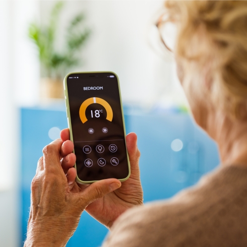 Adjust the Thermostat Woman adjusting thermostat from her phone.