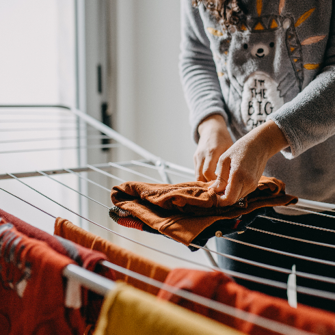 Air Dry Your Clothing Midsection Of Woman Holding Clothes On Clothesline At Home - stock photo