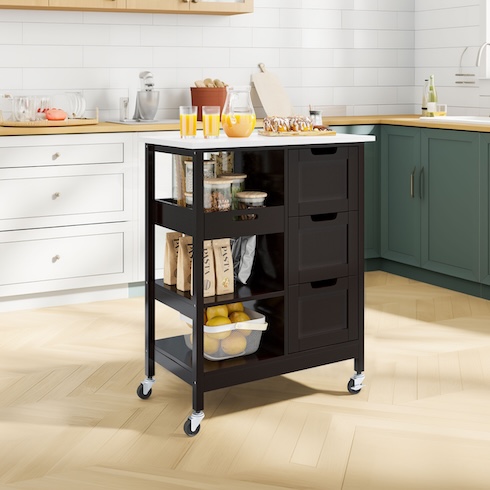 Add an Island A sleek black kitchen island with a jug of juice on the top and assorted containers, bags, and a bowl of fruit on the shelves underneath.