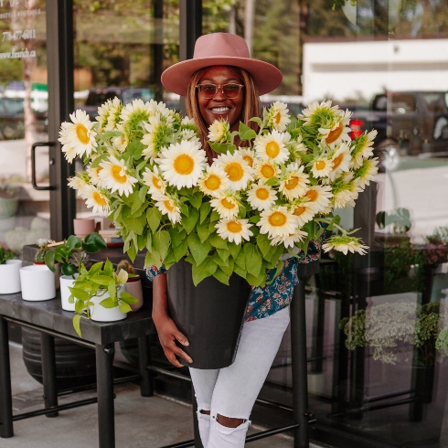 FleuRich Creations Laurence Rich of FleuRich Creations holding a large sunflower arrangement