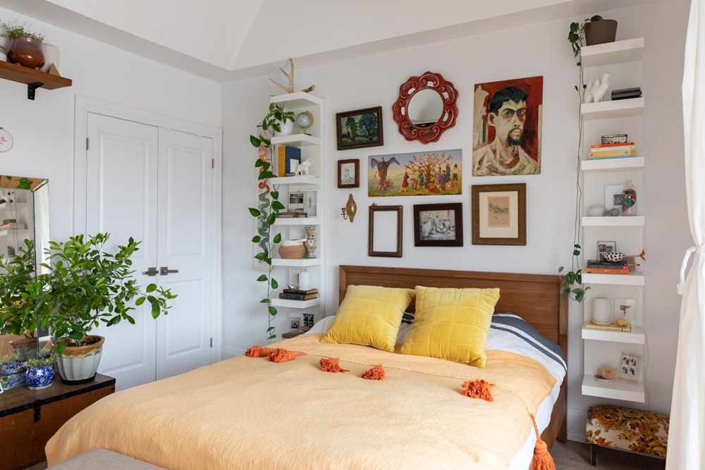 Floor-to-Ceiling Comfort Yellow bed with gallery wall above and white floating shelves beside