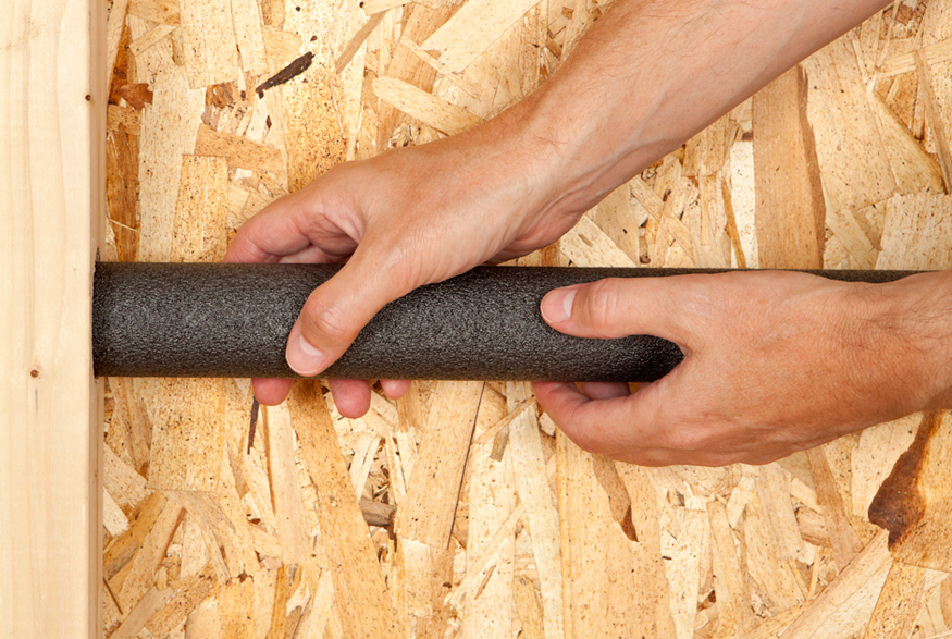 10. Insulate Hot Water Pipes Man insulating pipes