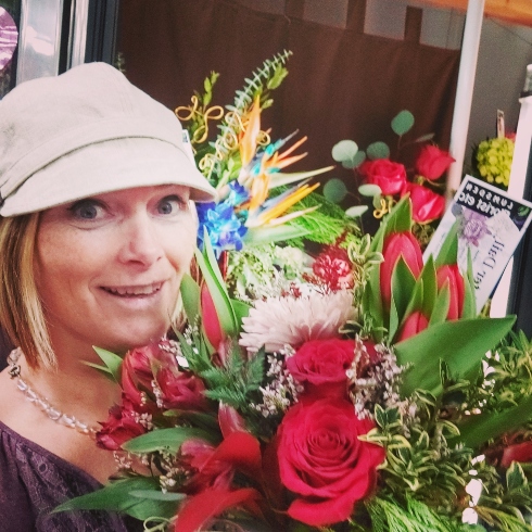 Lumsden Florist Florist Rachel Brimacombe of Lumsden Florist holding an arrangement with red flowers